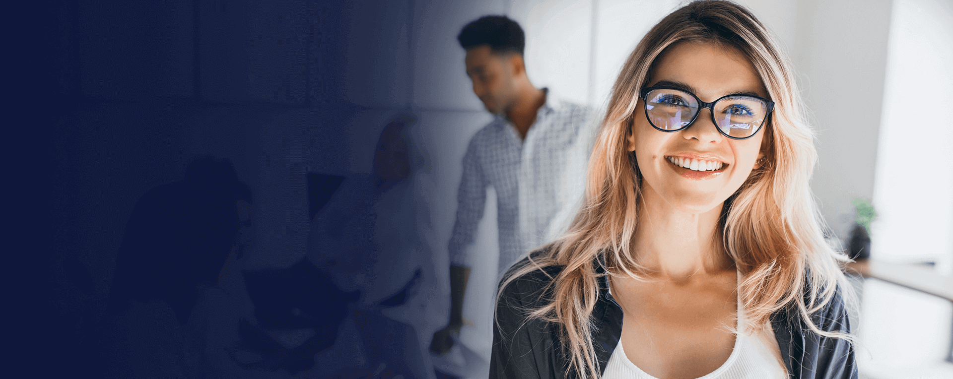 Professional woman in an office setting with colleagues in the background
